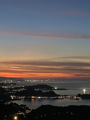 A coastal town at dusk with a view of the sea and distant city lights. - M Bar House (New Taipei City)