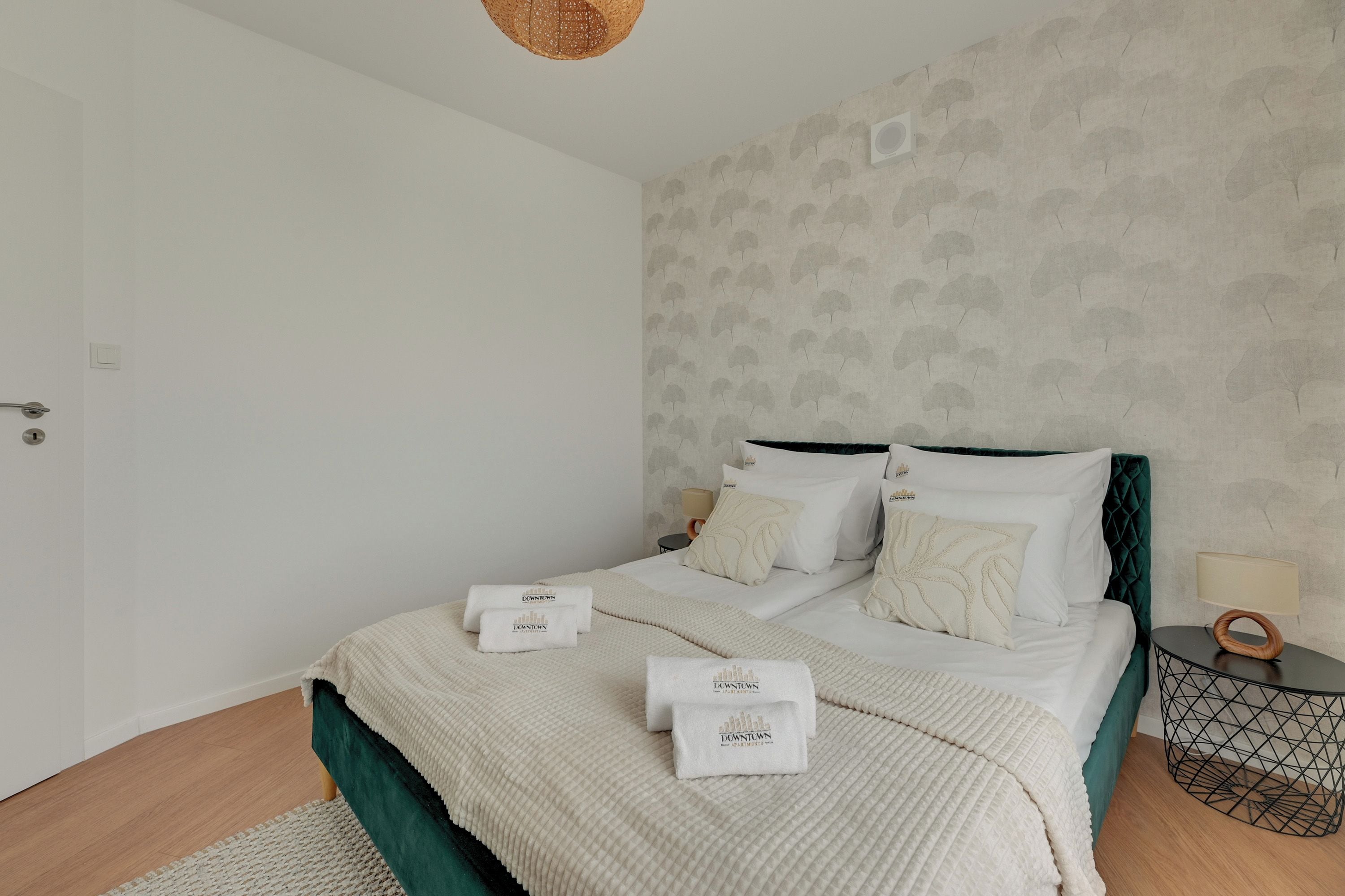 Ein Schlafzimmer mit einem Bett, Kissen, einem Nachttisch und einer Lampe.