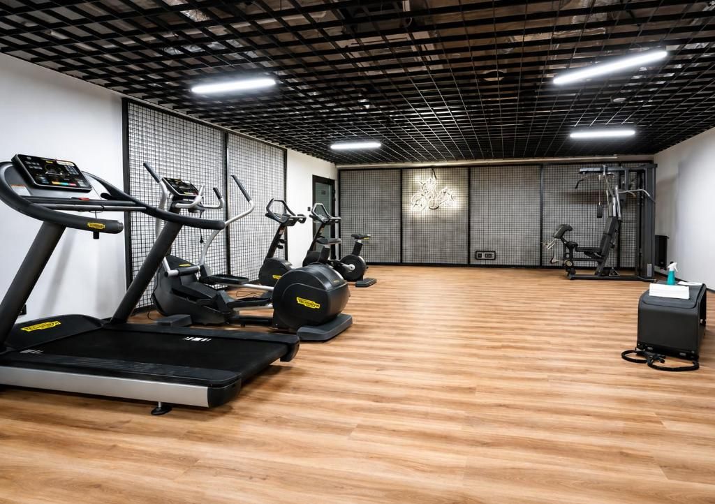 Ein Fitnessstudio mit Laufbändern, Crosstrainern und Gewichtsmaschinen.
