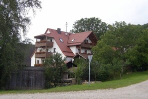 A multi-story house with a sloped roof, balconies, and a gravel driveway. - Holiday apartment with 2 bedrooms (Altdorf-Rasch)