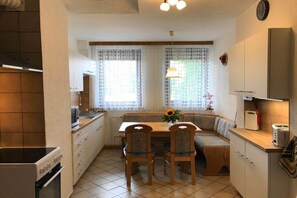 Una cucina compatta con zona pranzo, forno integrato e frigorifero.
