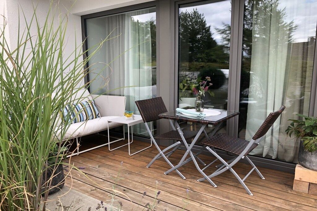 Un patio exterior con una mesa, sillas, un sofá y una planta en maceta.