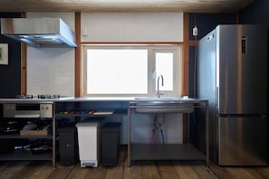 A modern kitchen with a stainless steel refrigerator, a built-in oven, and a window above the sink. - HETA Niseko [50-65% OFF for Weekly Stays | Sleeps Large Groups & BBQ Included] (ニセコ町)