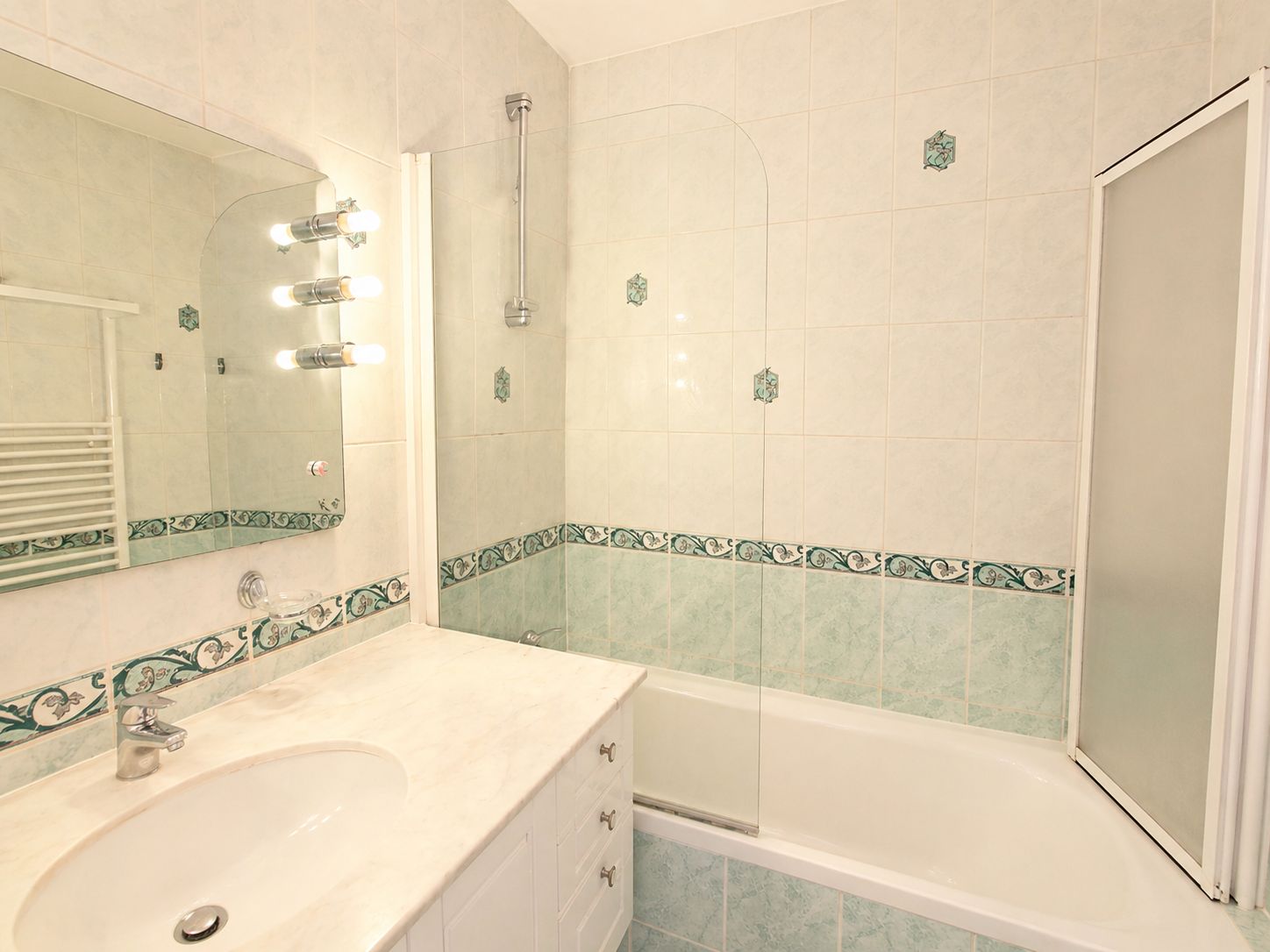 A bathroom with a sink, mirror, shower, and bathtub.
