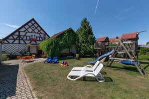 A traditional half-timbered house with a wooden play structure and a slide. - Holiday home in Ellingen with swimming pool (Ellingen)
