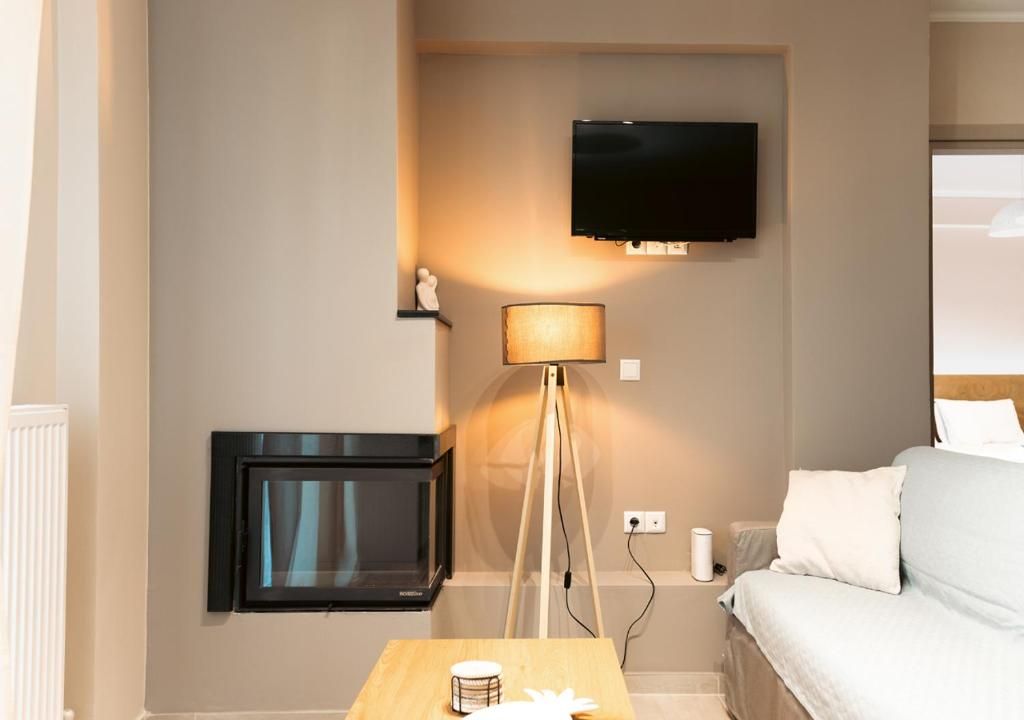 Ett hotellrum med en säng, en tv som är monterad på väggen, en lampa och ett litet bord.
