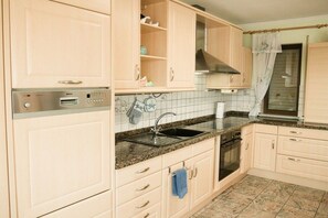 A kitchen with light-colored cabinets, a built-in oven, a sink, and a Bosch dishwasher. - Holiday home with 4 bedrooms (Ochtendung)
