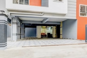 Una entrada de edificio con un vestíbulo techado que da acceso a un espacio interior.