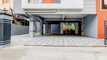 A modern building with a covered entrance and a tiled patio area.