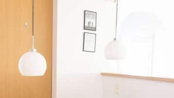 Uma área de refeições com mesa e cadeiras de madeira, luminárias pendentes e quadros nas paredes.