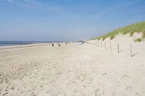 A sandy beach with a dune and a fence line. - Beach holiday and sea (St. Maartensvlotbrug)