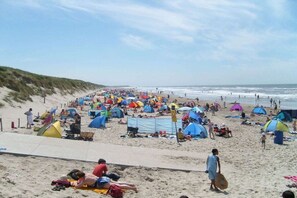 Een strand met tenten en mensen.
