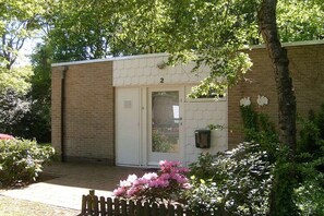 Un edificio con fachada de ladrillo, una puerta con número y un buzón.