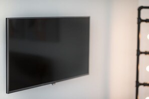 Seinälle asennettu litteänäyttöinen televisio.