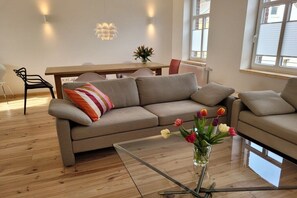 A modern living room with a sofa, a glass coffee table, and a vase of flowers. - Morning sun in the house Sonnen (Nettetal-Lobberich)