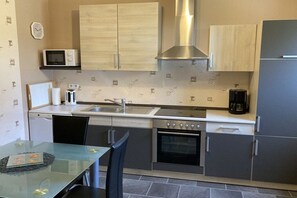 Cocina compacta con microondas, tostadora, lavamanos, estufa y alacenas.