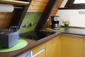 A kitchen with a stove, a coffee maker, and a sink. - Holiday home in Landau with swimming pool (Landau)