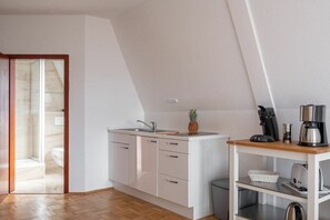 A modern kitchen with a white countertop, a sink, and a coffee machine. - La Perla - Longing for the Sea (Überlingen)