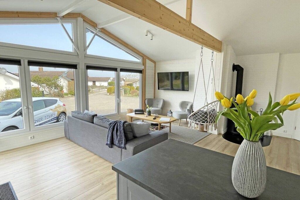 A modern living room with a sofa, coffee table, and a TV mounted on the wall.