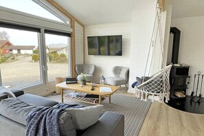 A modern living room with a sofa, chairs, a coffee table, and a fireplace. - Holiday home in Kappeln with swimming pool (Kappeln)
