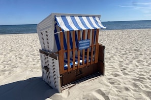 A beach chair with a striped awning and a sign indicating 'Villa Atlantic Apartment 4 Ostseeblick.' - Holiday apartment in Binz with swimming pool (Binz)
