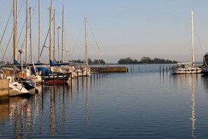 A marina with multiple sailboats docked at wooden piers. - Spacious holiday apartment in Petersdorf (Petersdorf\/Fehmarn)