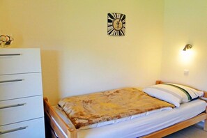 Ein Schlafzimmer mit einem Bett, einem Schminktisch und einer Wanduhr.
