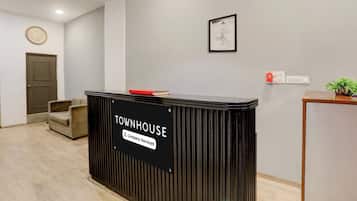 Ein Empfangstresen mit der Aufschrift 'TOWNHOUSE' und einem Schild, das 'Firmenbetreutes Apartment' anzeigt.