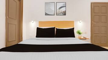 A bed with a wooden headboard, two black pillows, a white bedspread, and a black throw blanket. There are two wall-mounted light fixtures on either side of the bed, and a potted plant on a bedside table.
