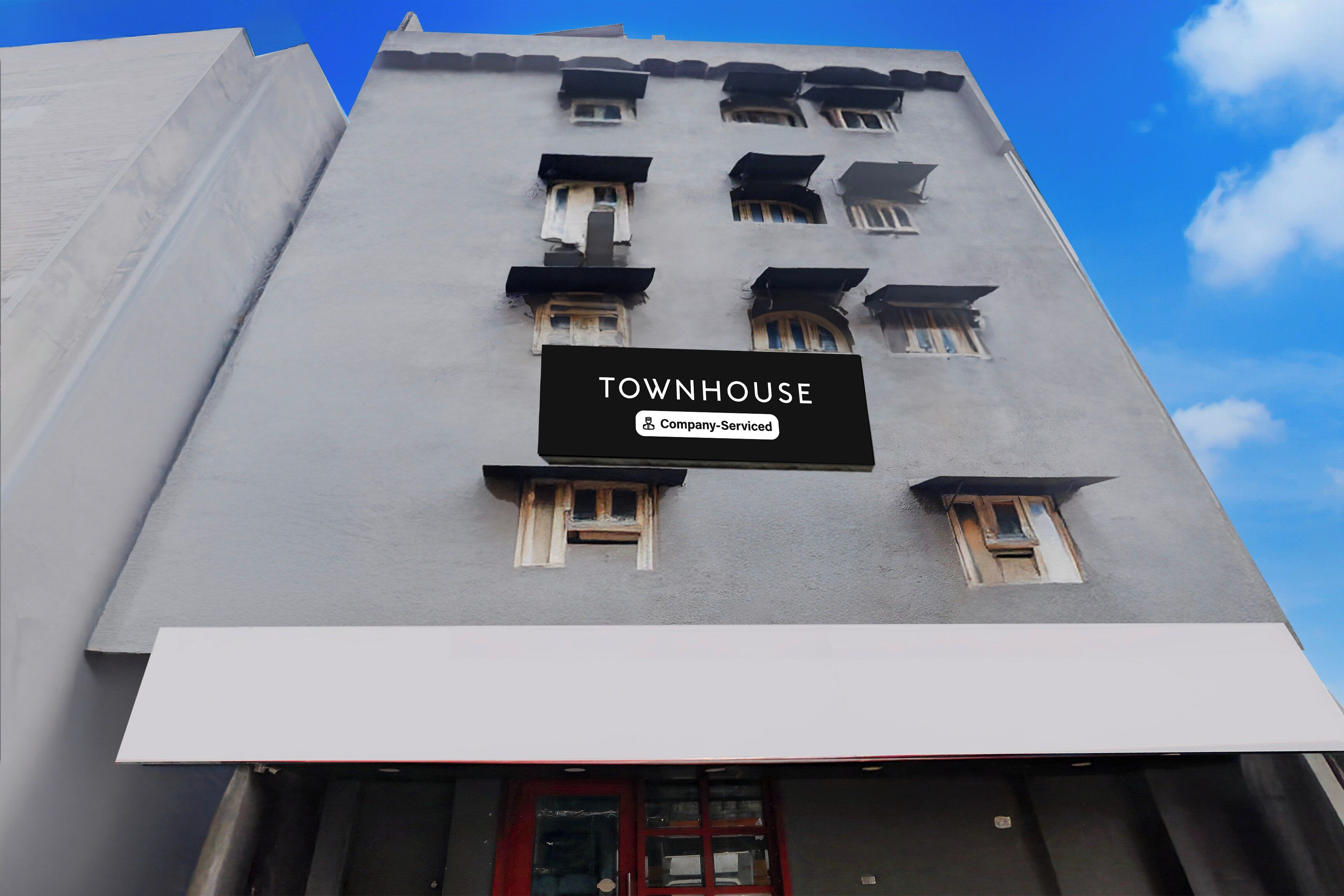 A building with a sign that reads 'TOWNHOUSE' and 'Company-Serviced.'