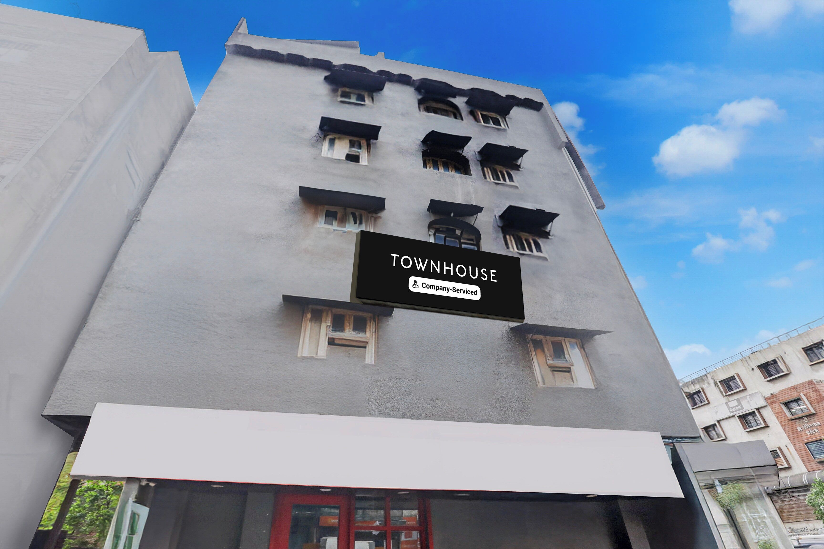 Un immeuble sur lequel on peut lire l’inscription : « TOWNHOUSE, services d’entreprise ».