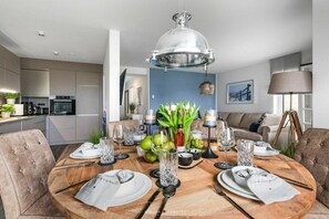Un comedor moderno con una mesa redonda de madera dispuesta para cuatro personas, rodeada de sillas.