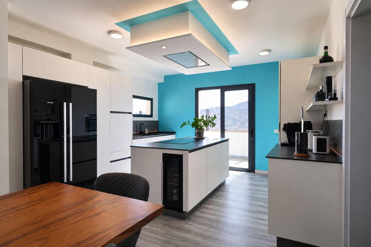 A modern kitchen with a central island, a dining table, and a view of the outdoors.