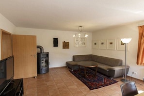 A living room with a sofa, a coffee table, a fireplace, and a floor lamp. - Holiday home with 3 bedrooms (Born a. Darß)