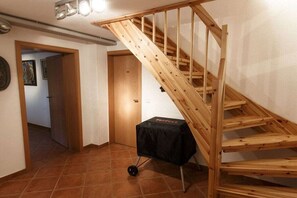 En trætrap i en gang med et bord dækket af et sort klæde.