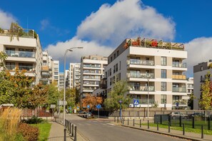 Een moderne straat in de stad met meerhoog gebouwen, een voetgangersoversteek en een heldere lucht.