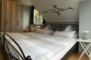 Une chambre à coucher comprenant un lit, une armoire, une table de chevet et un élément décoratif mural.