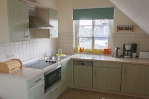 A compact kitchen with a sink, stove, and dishwasher. - Holiday apartment with 2 bedrooms (Wieck a. Darß)