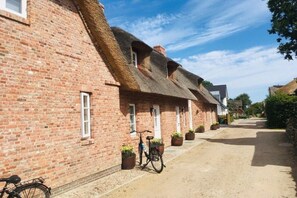 A row of traditional brick houses with thatched roofs and a bicycle parked in front. - 4 Caymans at Boldix House (Wyk-Boldixum)