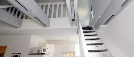 A modern kitchen with white cabinets and a built-in microwave.