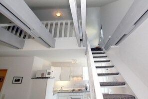 A modern kitchen with white cabinets and a built-in microwave. - Waldstrasse - Holiday Apartment 26 (Wyk auf Föhr)