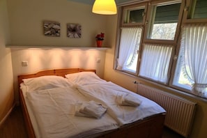 A neatly made bed with pillows and a bedside table with a lamp. - Otto House - Holiday Apartment 1 (Wyk auf Föhr)