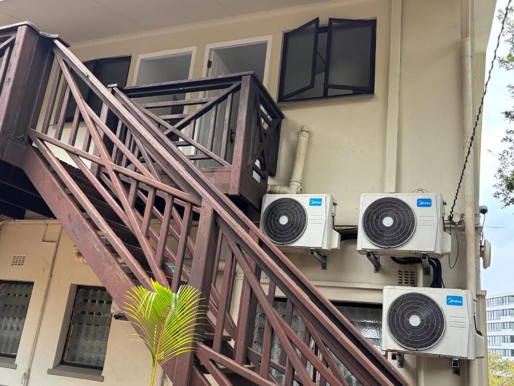A multi-story building with a staircase, air conditioning units, and windows.