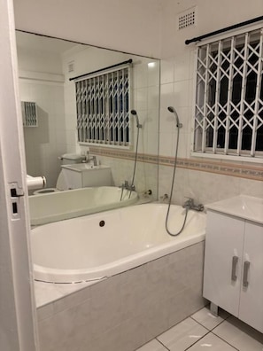 Ein Badezimmer mit einer Badewanne, einem Waschbecken und einem Spiegel.