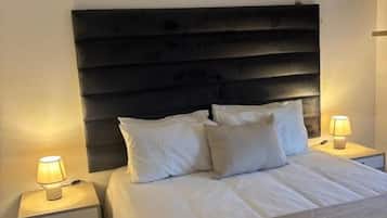 Quarto de hotel com cama, abajures, mesa de cabeceira e ar condicionado.