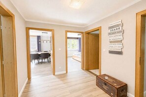 A hallway with wooden flooring, a dining area with a table and chairs, and a wall with family rules. - Holiday apartment with 1 bedroom (Wyk auf Föhr)