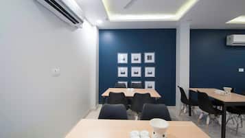 A conference room with tables, chairs, and framed pictures on the wall.