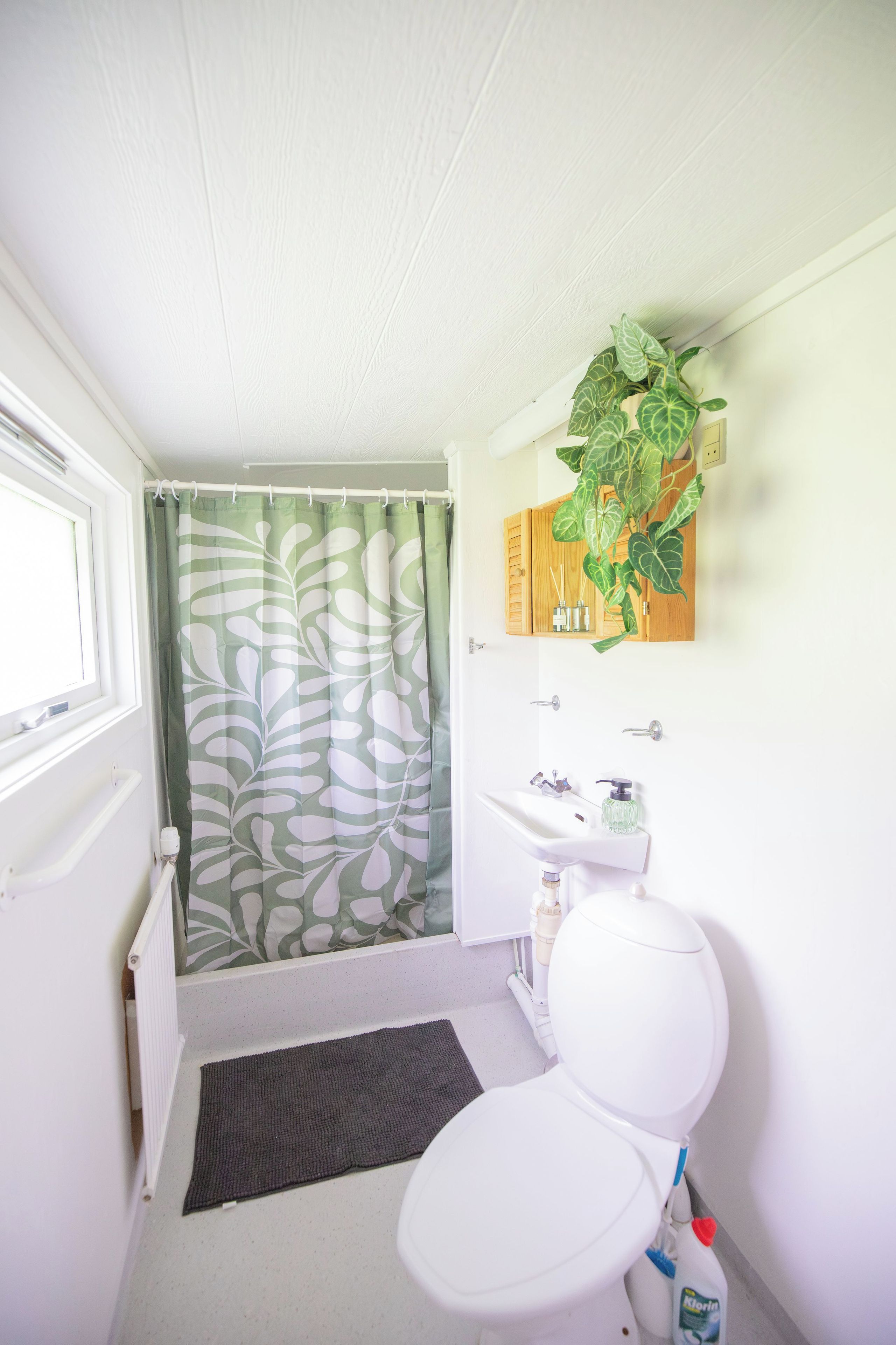 A small bathroom with a toilet, sink, and shower curtain.