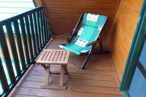 A wooden deck with a wooden table and a single lounge chair. - Holiday home in the Baltic Sea with 2 bedrooms (Mielenko \/ bei Mielno)