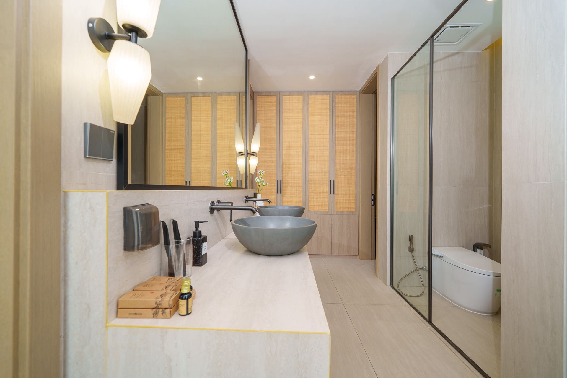 A modern bathroom with a large mirror, two sinks, and a glass-enclosed shower.